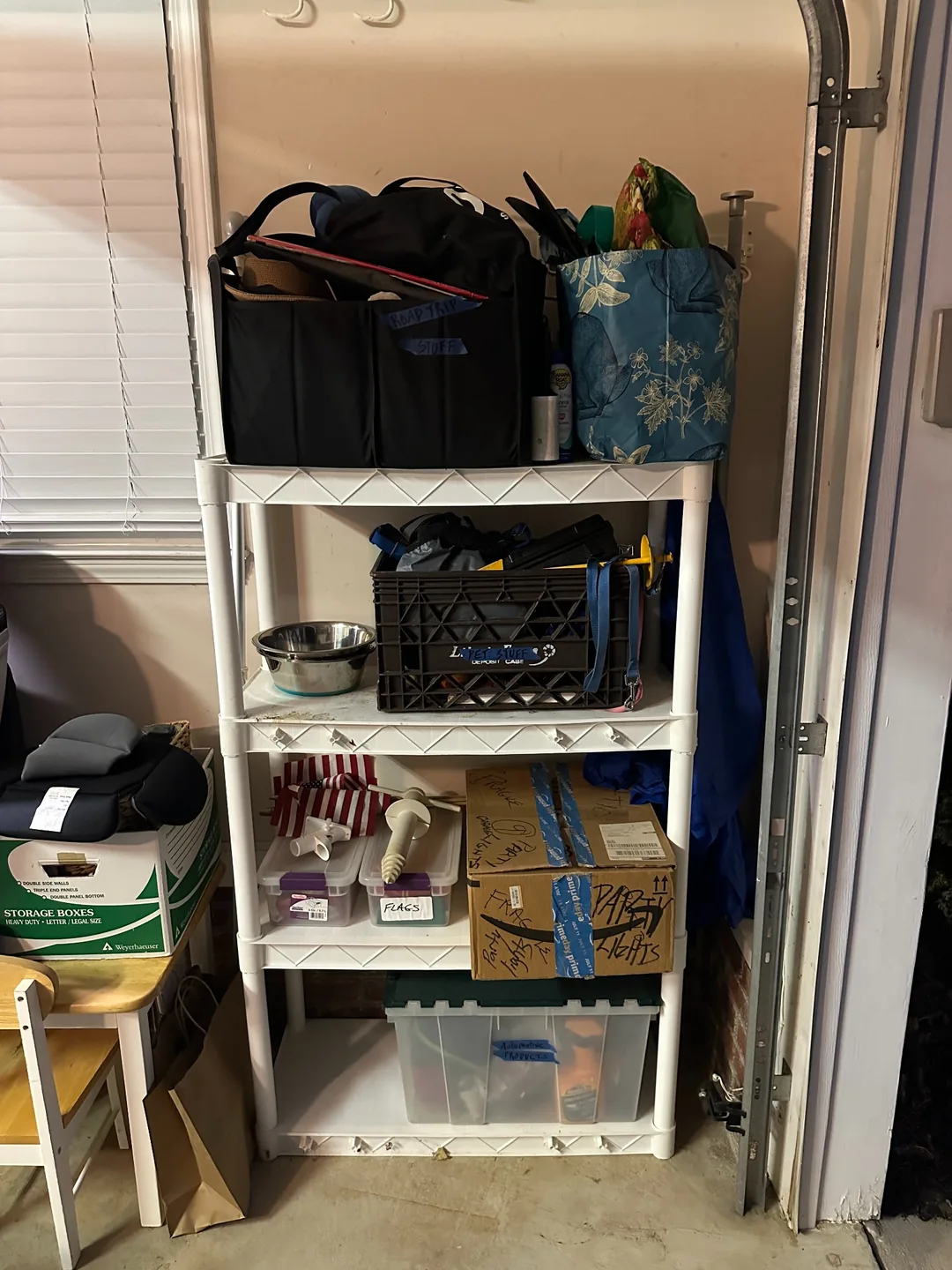 White shelving with separate places for travel, pet, and automotive supplies.