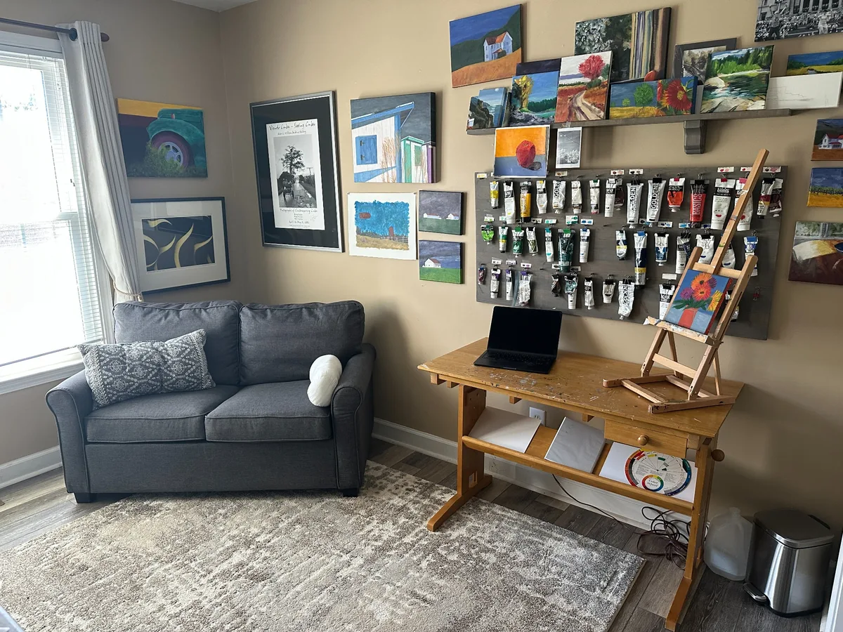 A finished, inviting art studio with a clear worktable and comfortable seating.